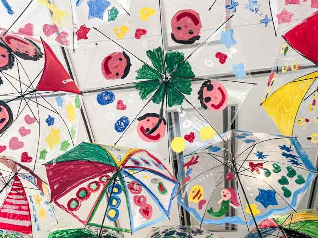天井に展示された町内の園児たちのイラスト入りビニール傘