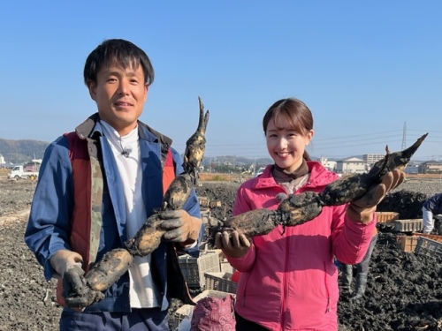 れんこんを手に持つ高橋幹雄さんと古米キャスター