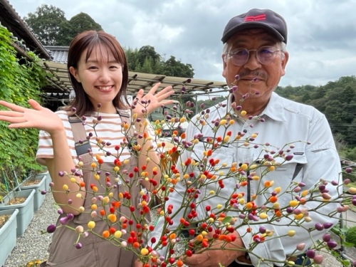 花トウガラシを持った賢二さんと難波アナ