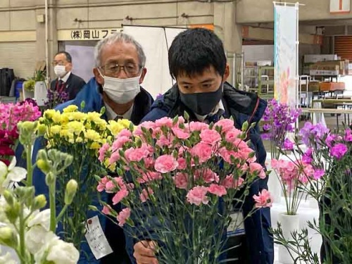真剣な表情で花を見つめる審査員