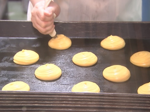 美咲町産の牛乳と卵を使った生地を鉄板に載せる作業