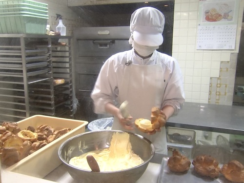 シュークリーム生地にクリームはさむ作業